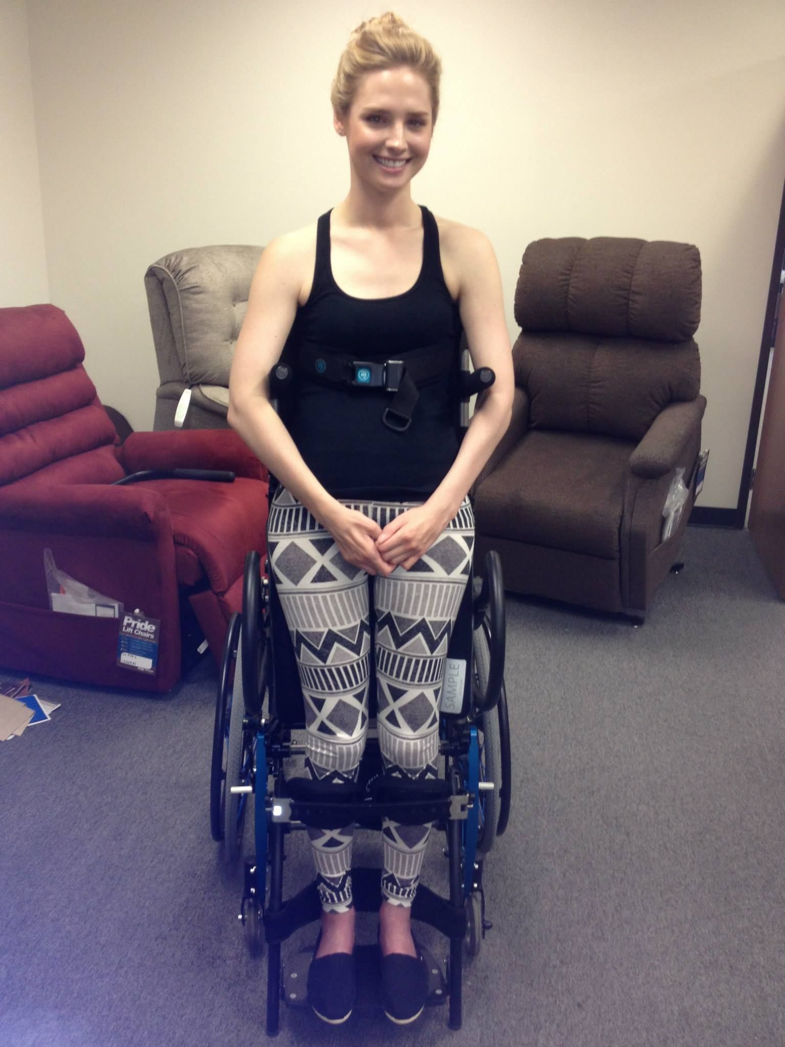 A woman in a black tank top is sitting in a wheelchair