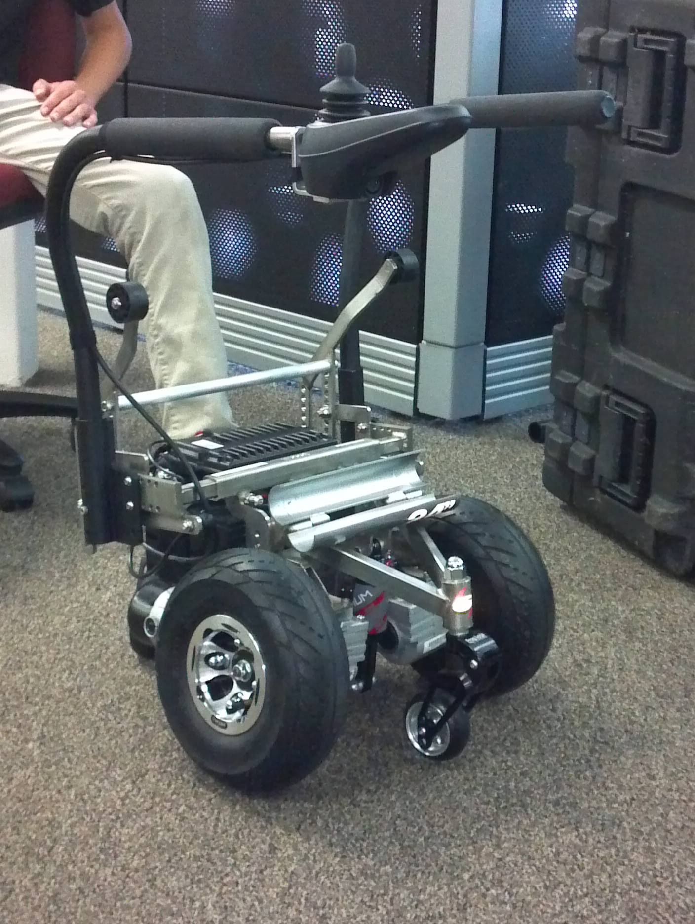 A man sits in a chair next to a wheelchair