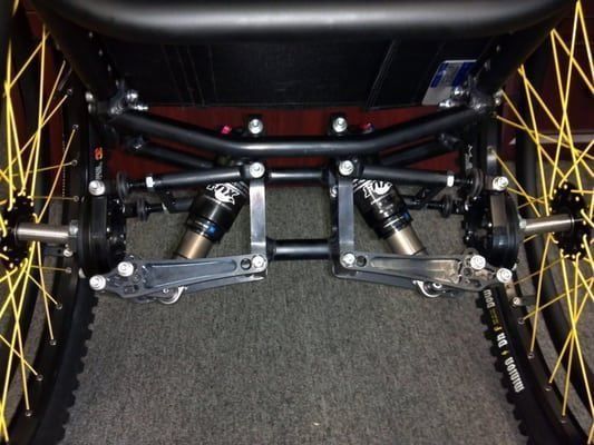 A close up of a wheelchair with yellow spokes
