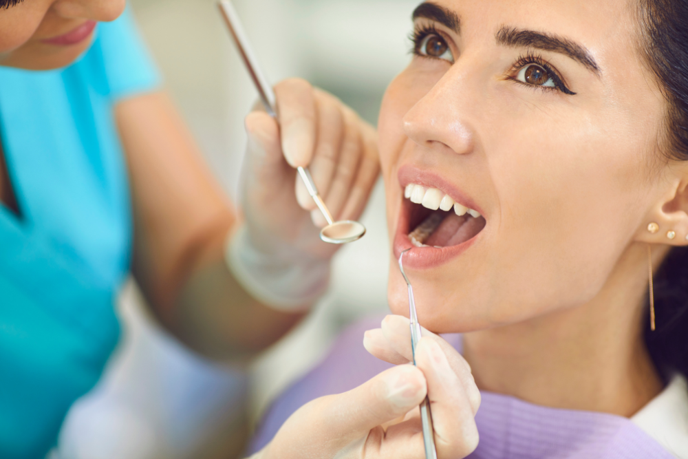 A woman is getting her teeth examined by a dentist.