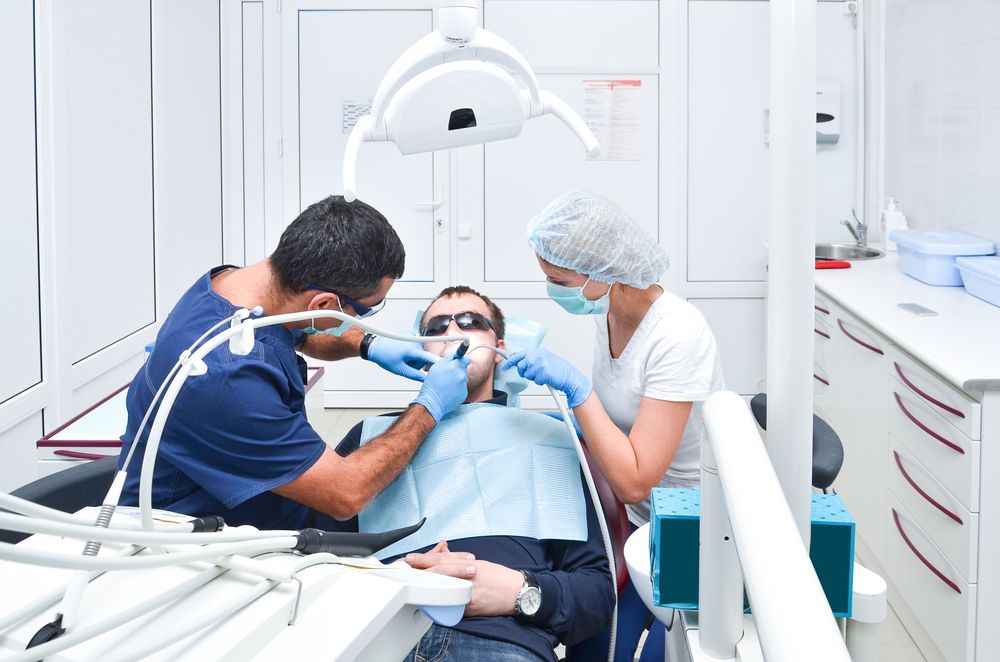 A woman is getting her teeth examined by a dentist.