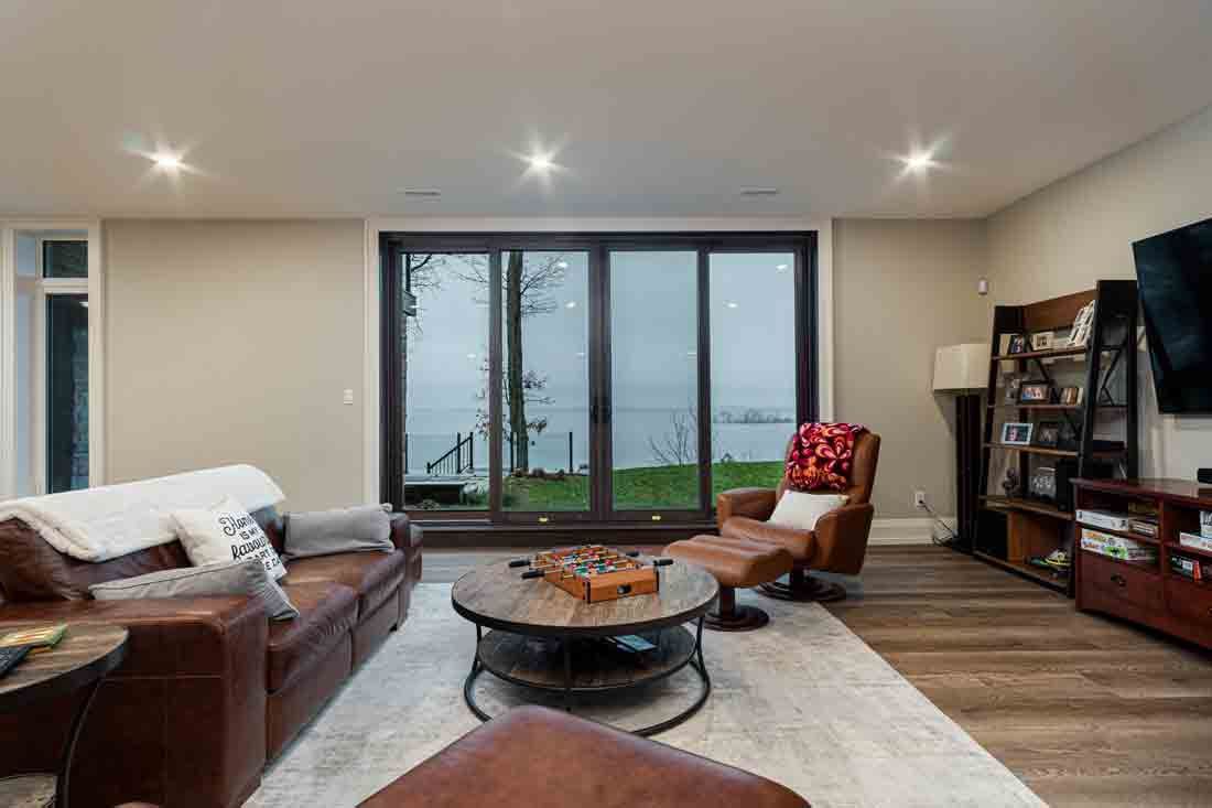 Modern living room with sofa, coffee table, armchair, and sliding glass doors to a patio