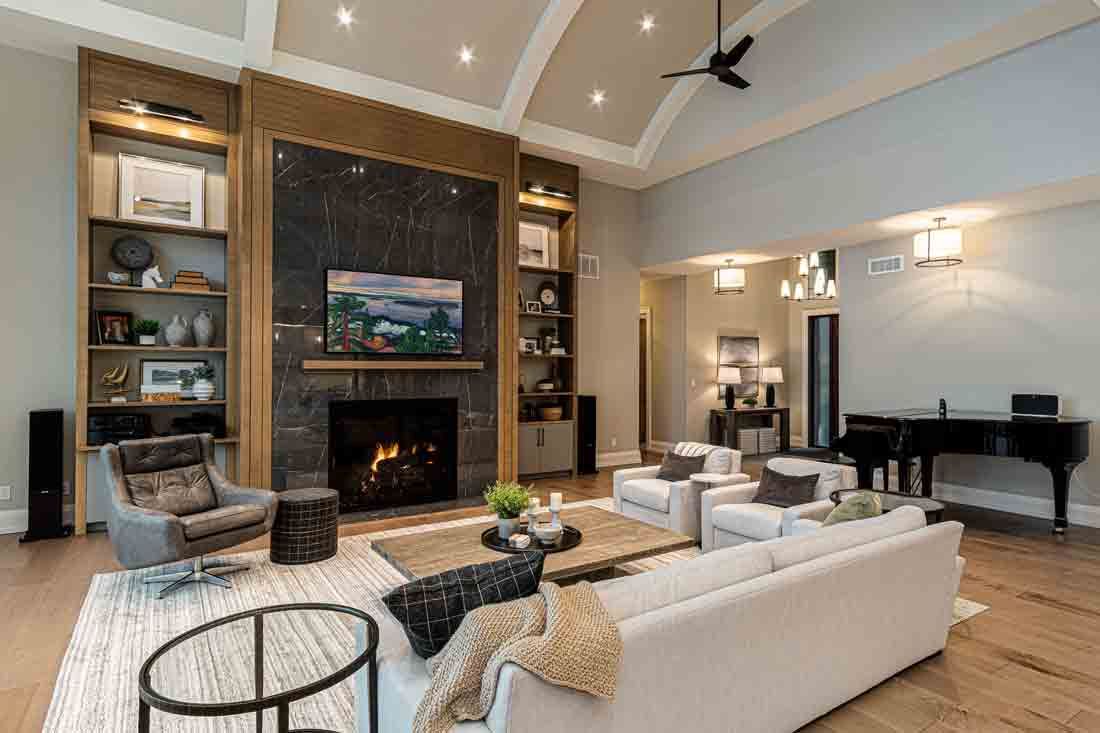 Modern living room with a fireplace, white sectional sofa, and grand piano