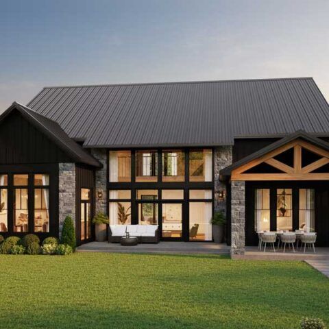 Modern two-story house with a dark roof, large windows, and a green lawn at dusk