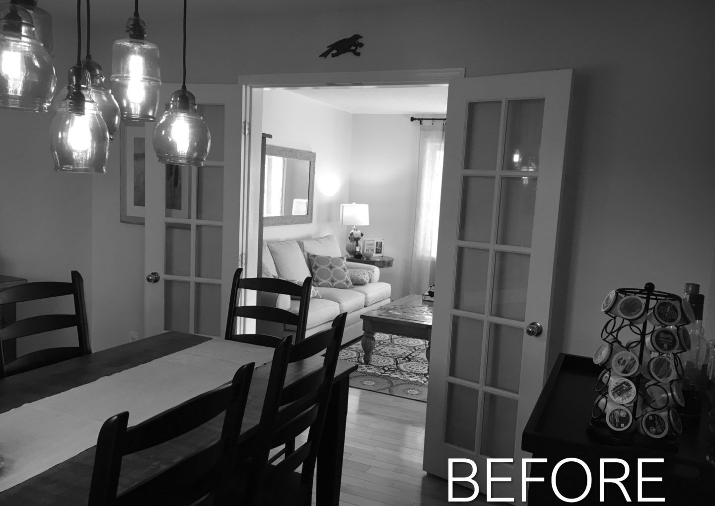 Dining room looking into a bright living room, with chandelier and chairs in the foreground and “BEFORE” text.