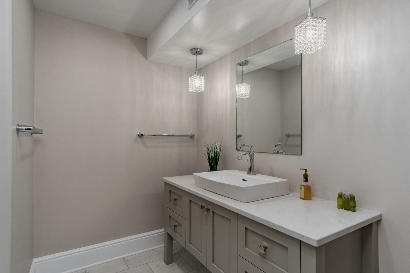 Bright modern bathroom with double vanity, large mirror, white walls, and chrome fixtures