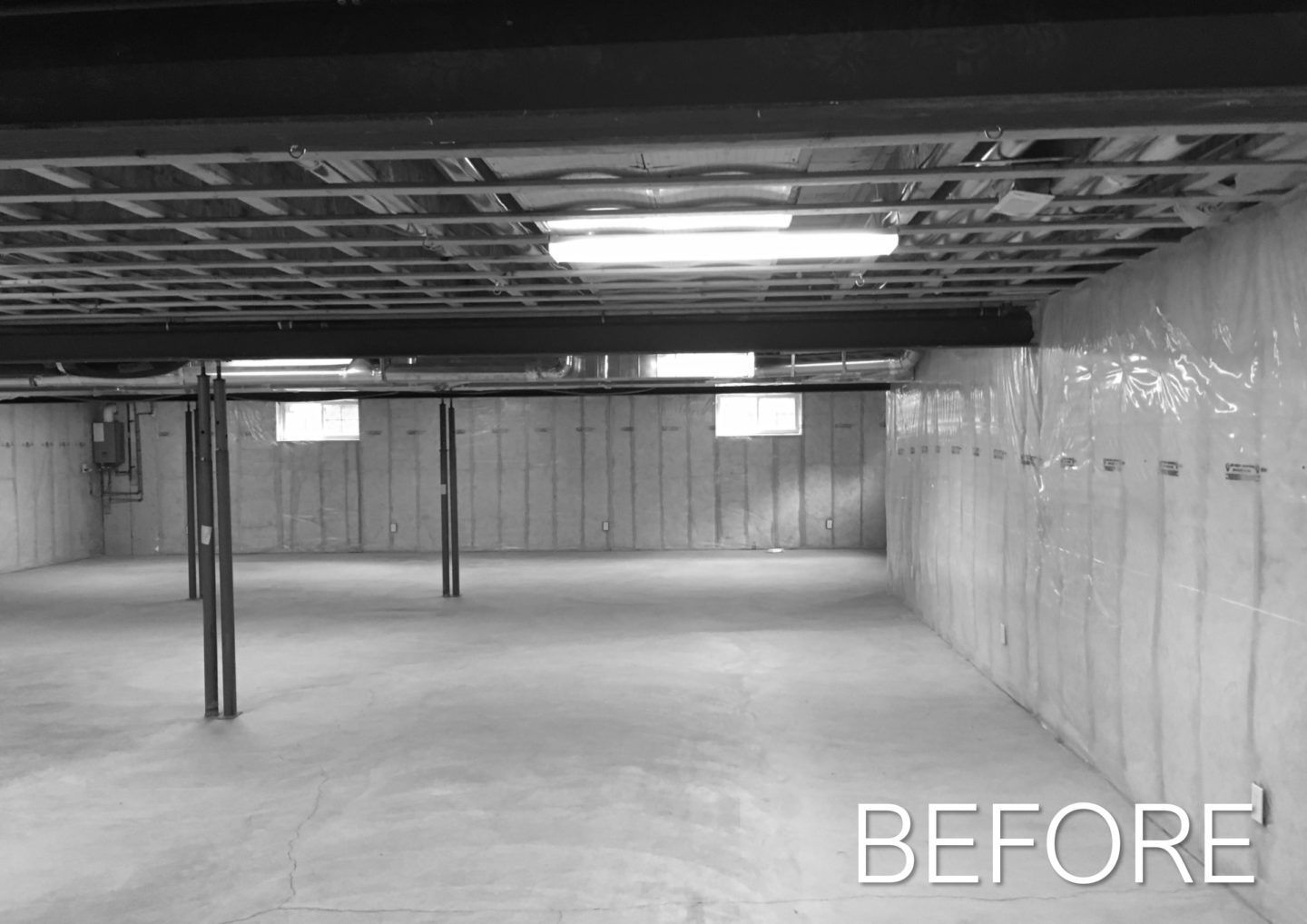 Empty unfinished basement with exposed ceiling, concrete floor, and wall insulation, labeled “BEFORE”