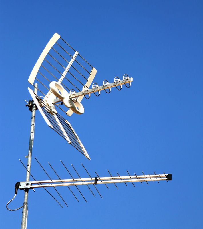 Due antenne televisive sul tetto, stagliate contro un cielo azzurro e limpido.