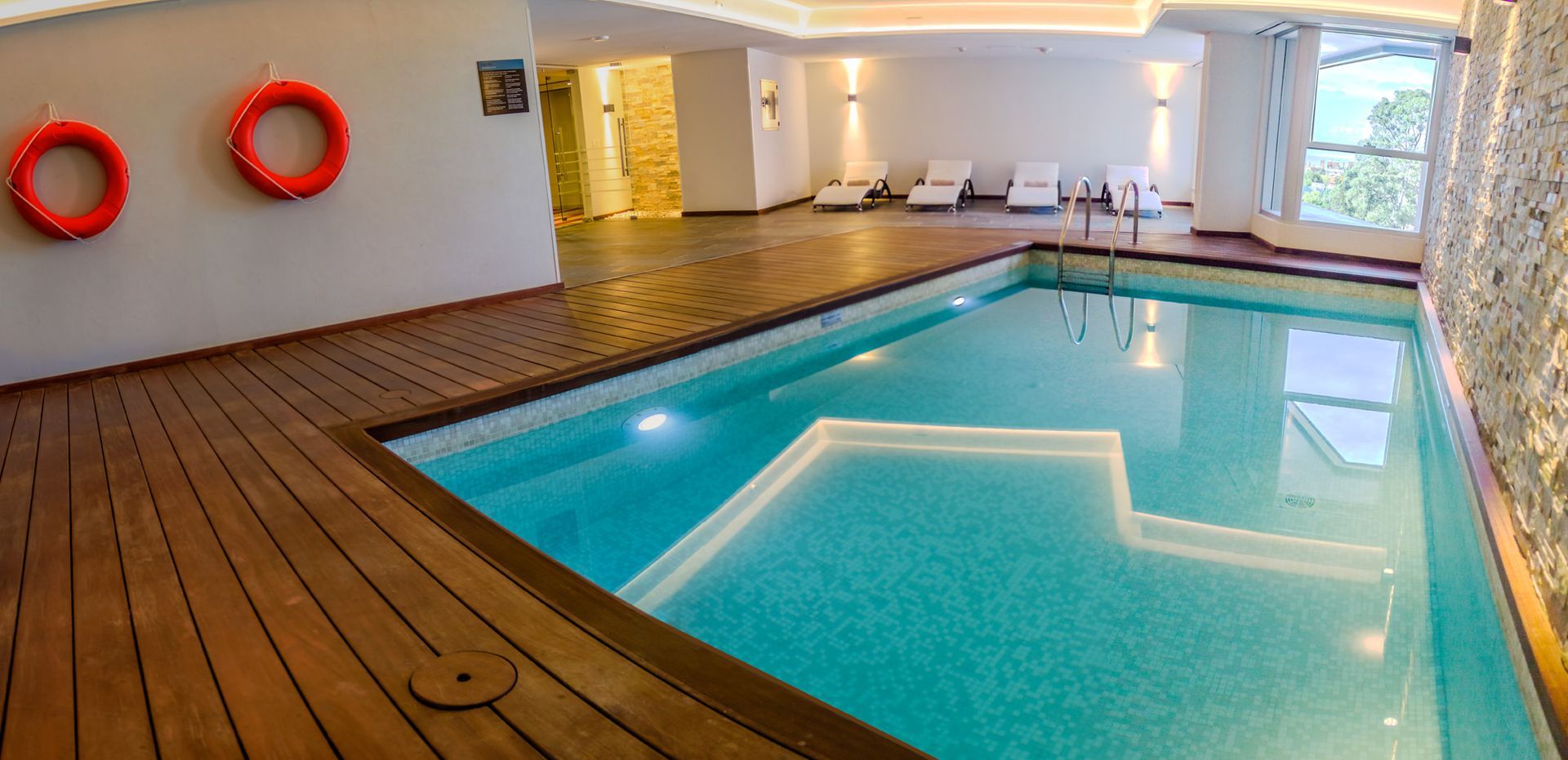 Una gran piscina cubierta con dos salvavidas en la pared.
