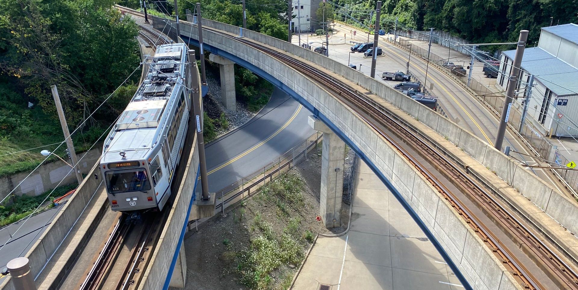 An aerial view of a train going over a bridge.