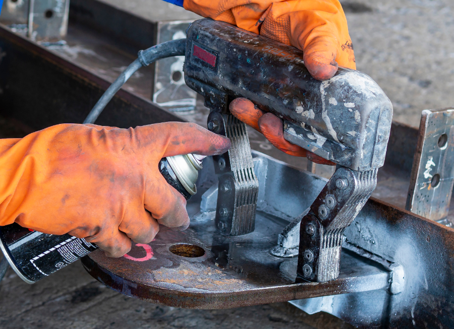 A person is using a magnetic detector on a piece of metal.