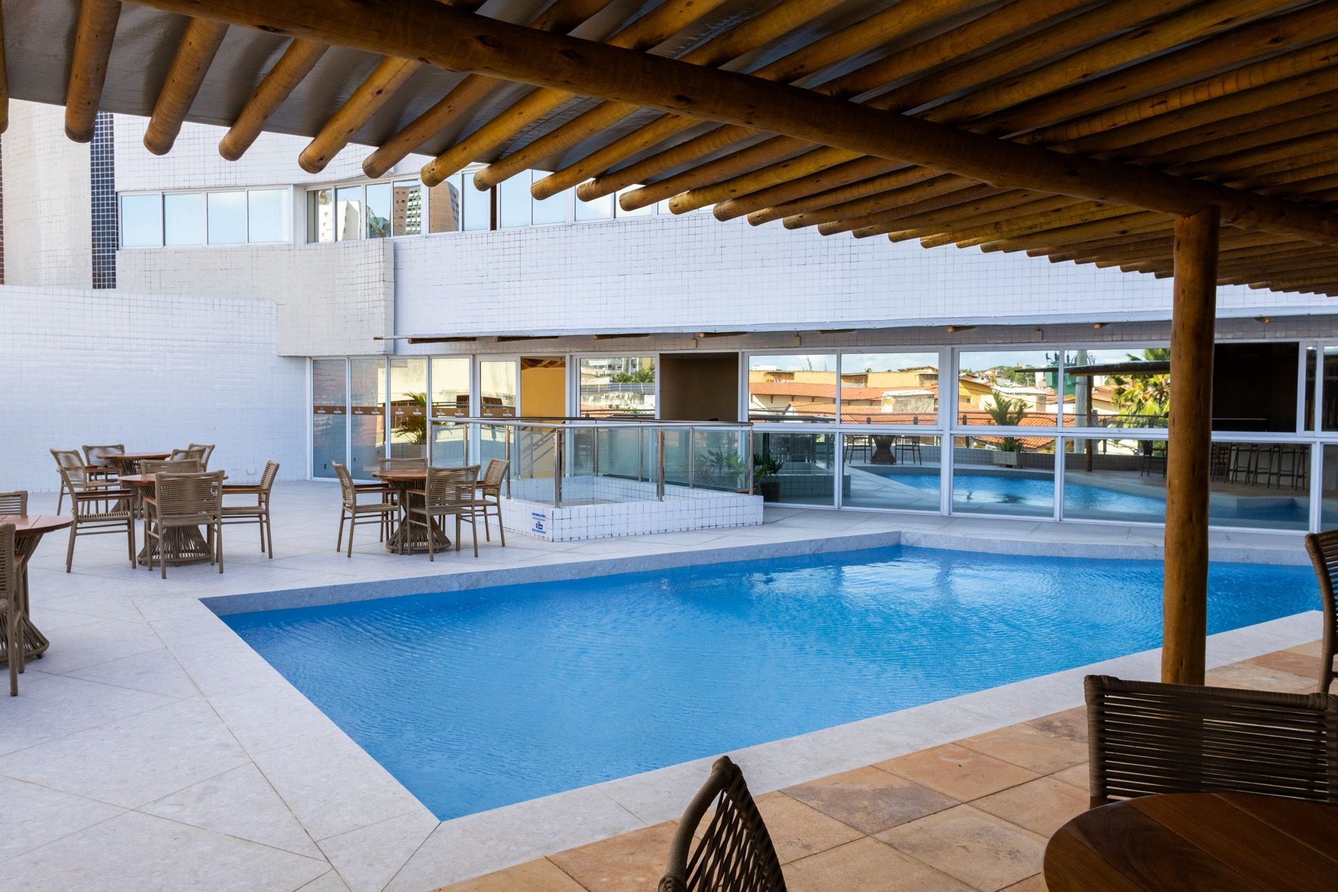 Uma grande piscina com mesas e cadeiras ao redor