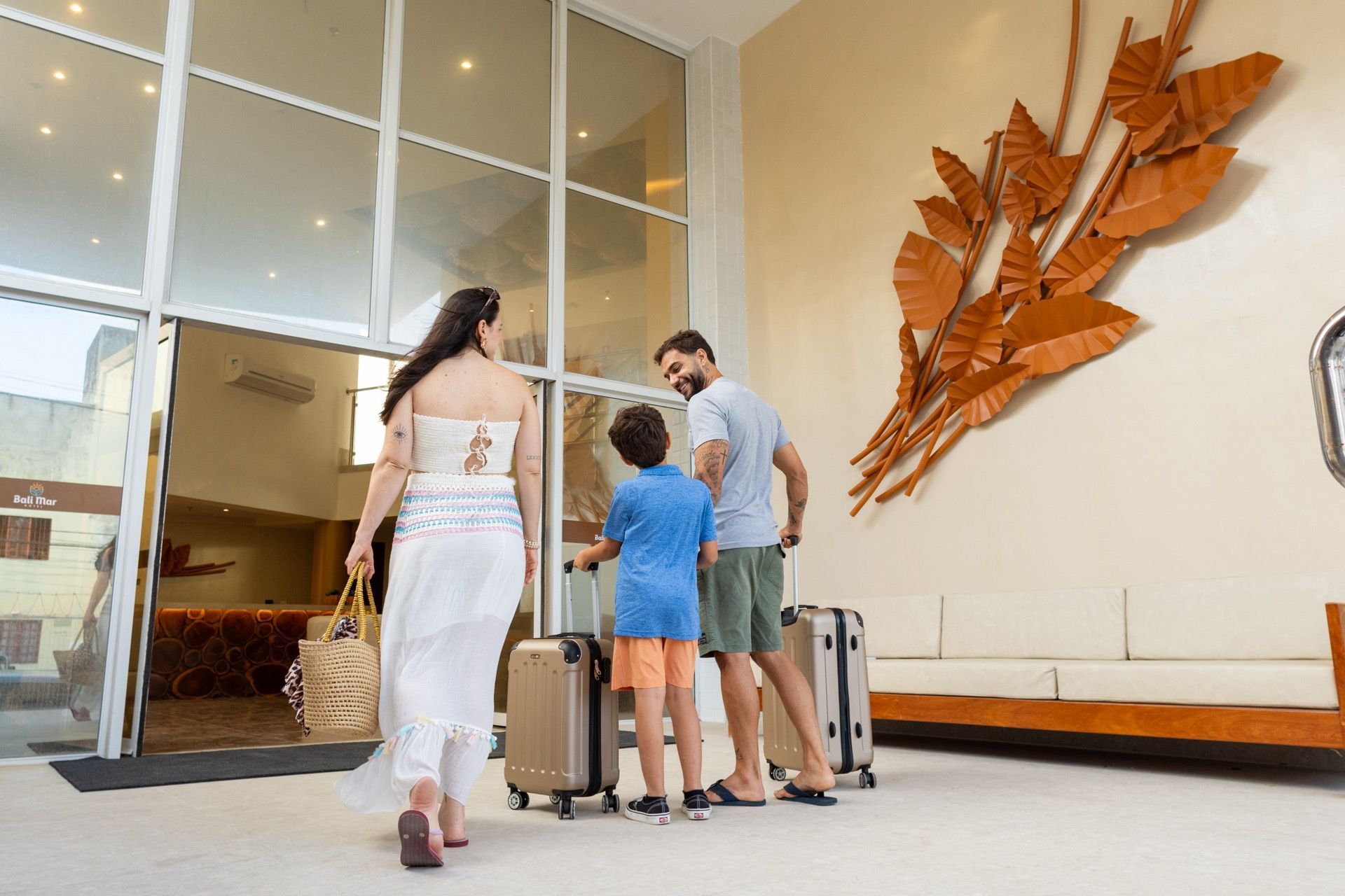 Uma família com bagagem está entrando no saguão de um hotel.