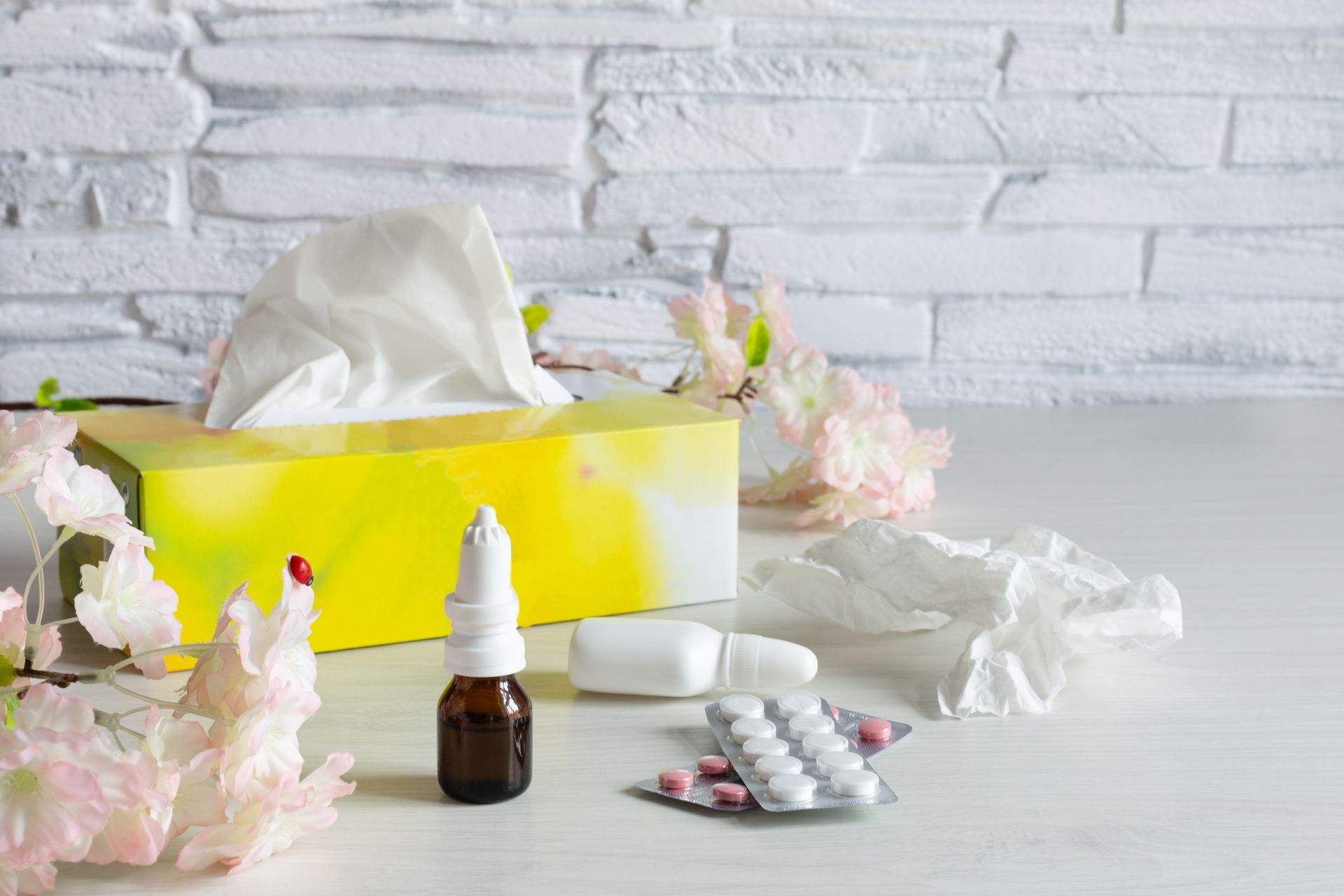 Table with box of tissues and medications