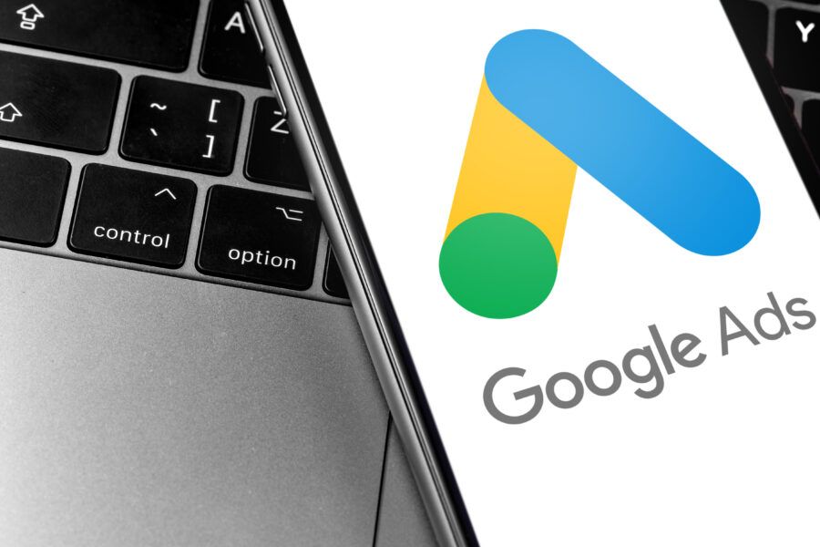 Google Ads logo on phone on top of a laptop