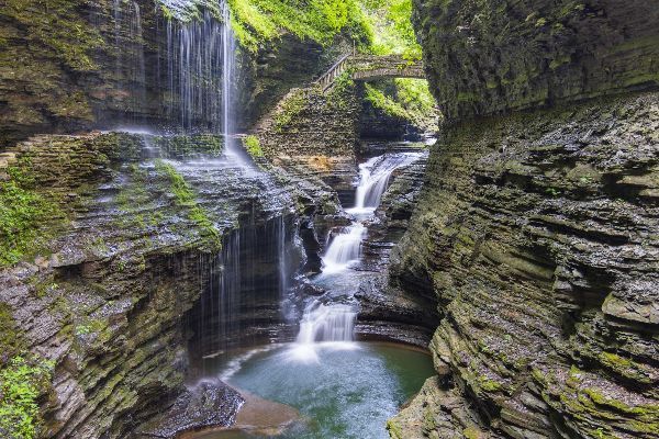 Waterfall cascading through a mossy rocky gorge into a small pool