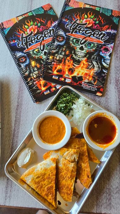 Two menus and a tray with quesadillas, sauces, onions, cilantro.