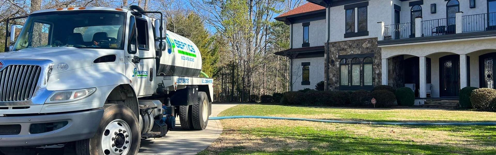 A white truck next to a house with green lawn.