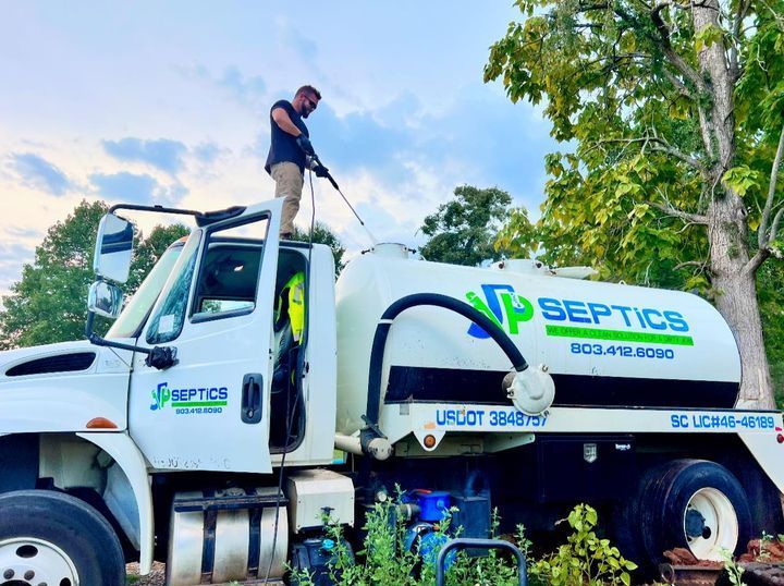 Man spraying a septic tank truck. White truck with 