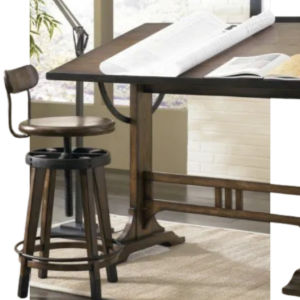 Drafting table with an open book and a stool in a bright studio workspace