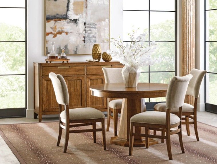 Elegant dining room with wooden chairs and a long table set by large windows