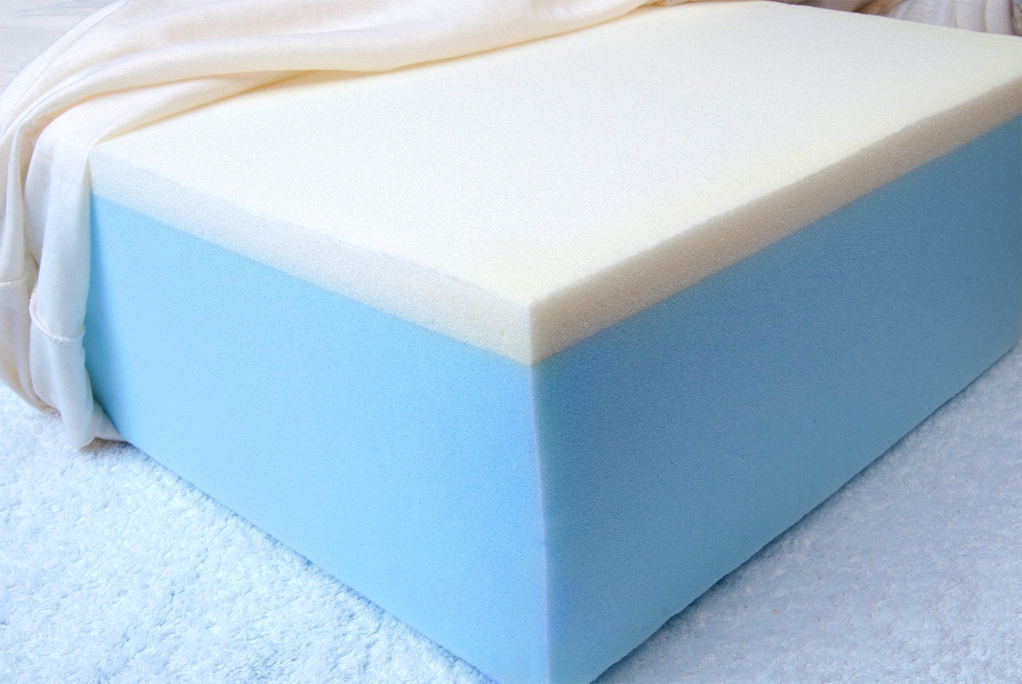 Blocco di schiuma blu e bianca con un tessuto drappeggiato sulla parte superiore.
