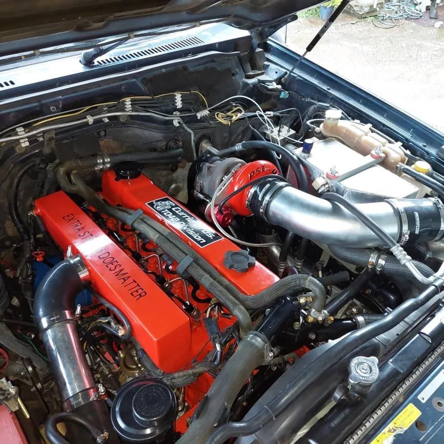 A Close Up of a Car Engine With the Hood Open — Currie Bros Engine Reconditioners in Taree, NSW
