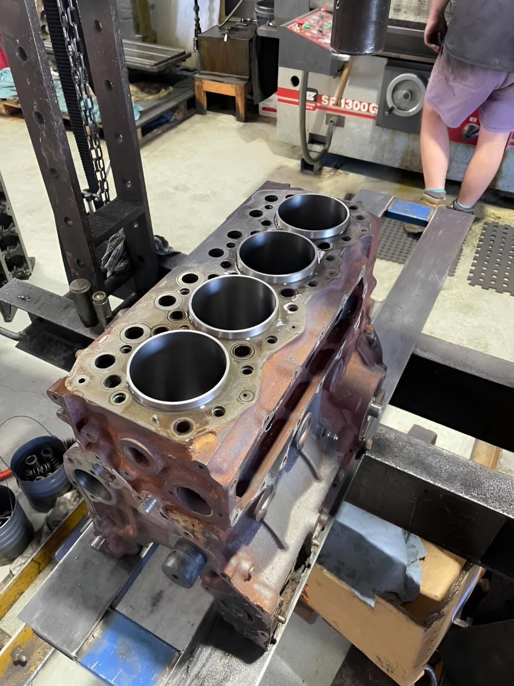 A Man is Working on a Cylinder Block in a Factory — Currie Bros Engine Reconditioners in Wauchope, NSW