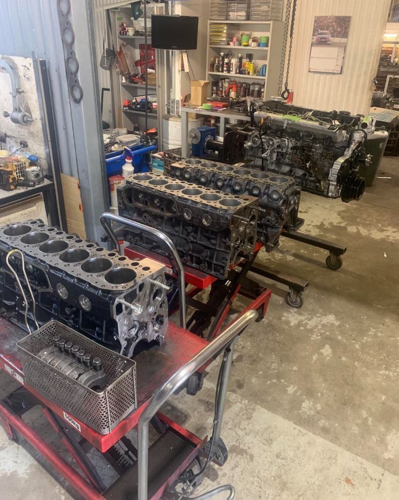 A Bunch of Engines Are Sitting on a Cart in a Garage — Currie Bros Engine Reconditioners in Taree, NSW