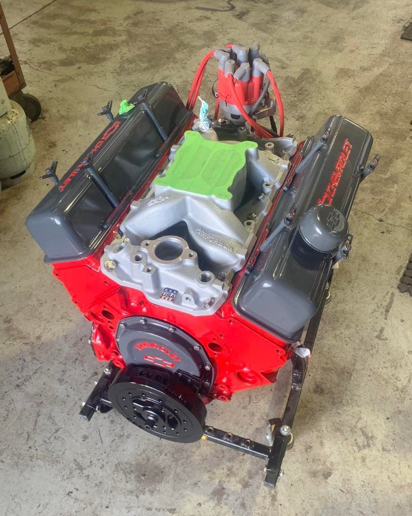 A Red Chevrolet Engine is Sitting on a Stand in a Garage — Currie Bros Engine Reconditioners in Hallidays Point, NSW