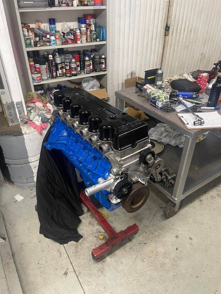 A Blue Engine is Sitting on Top of a Table in a Garage — Currie Bros Engine Reconditioners in Laurieton, NSW