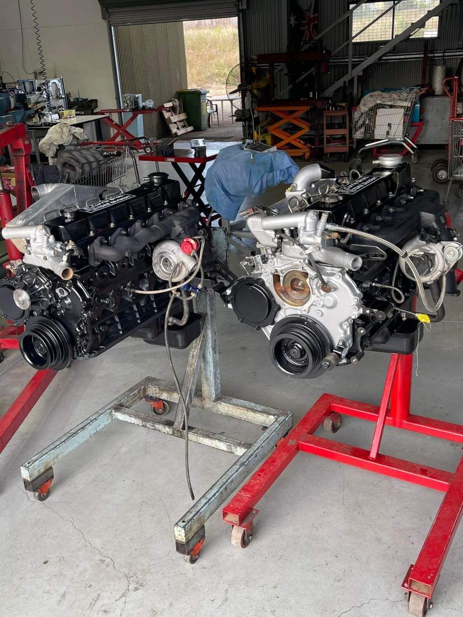 Two Engines Are Sitting on Red Stands in a Garage — Currie Bros Engine Reconditioners in Taree, NSW