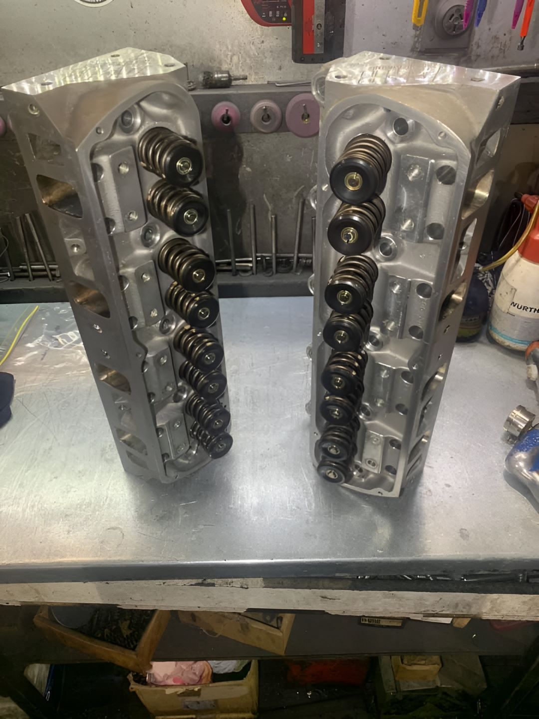 Two Cylinder Heads Are Sitting on Top of a Metal Table — Currie Bros Engine Reconditioners in Kempsey, NSW