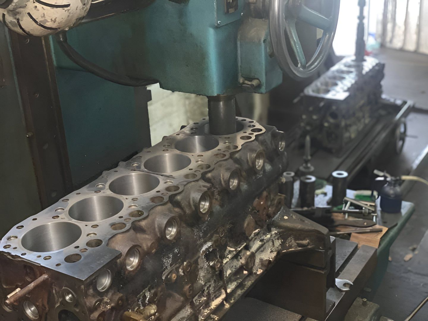 A Machine is Working on a Piece of Metal on a Table — Currie Bros Engine Reconditioners in Coffs Harbour, NSW