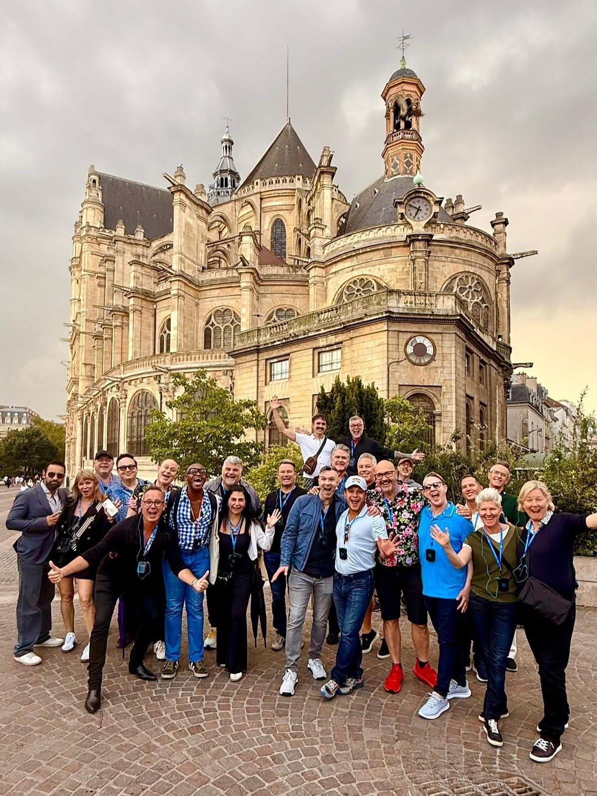 Group posing in front of an ornate historic building at dusk