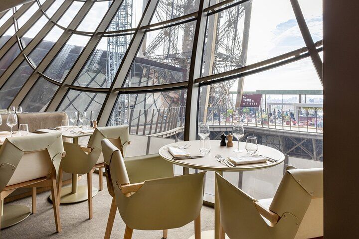 Modern café seating by a large curved glass window overlooking a city street