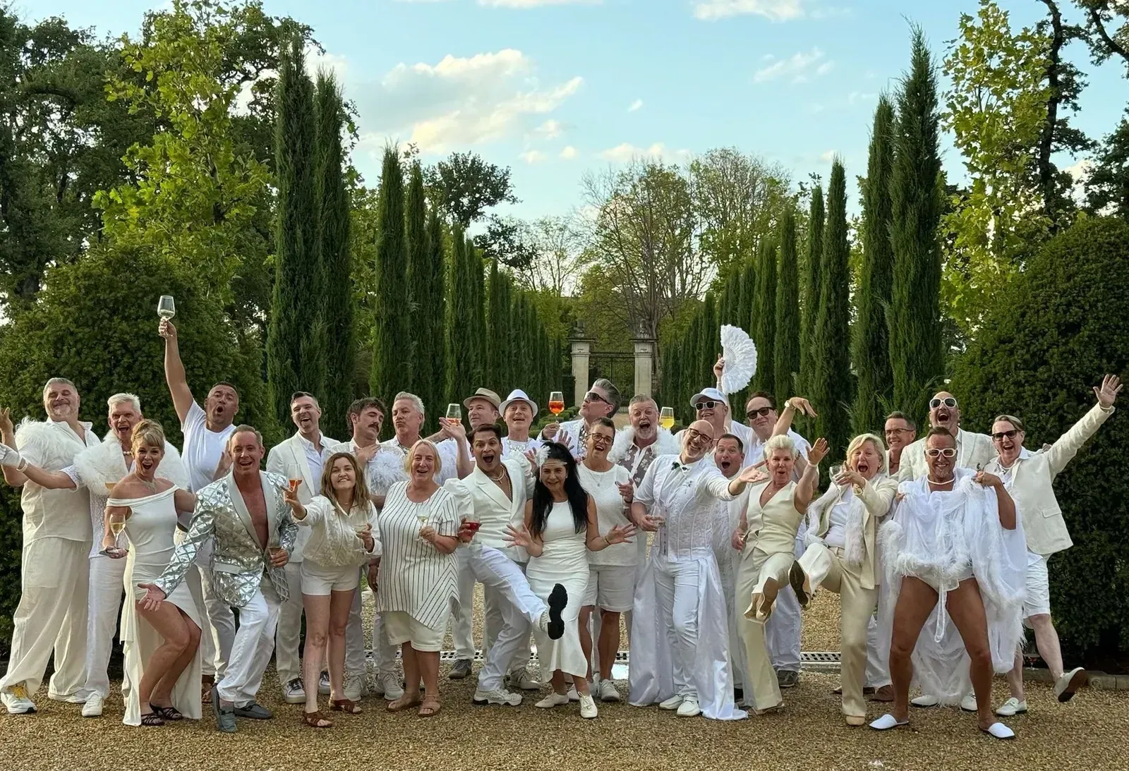 Hermes Holidays guests dressed in white celebrating in the garden of our Provence château