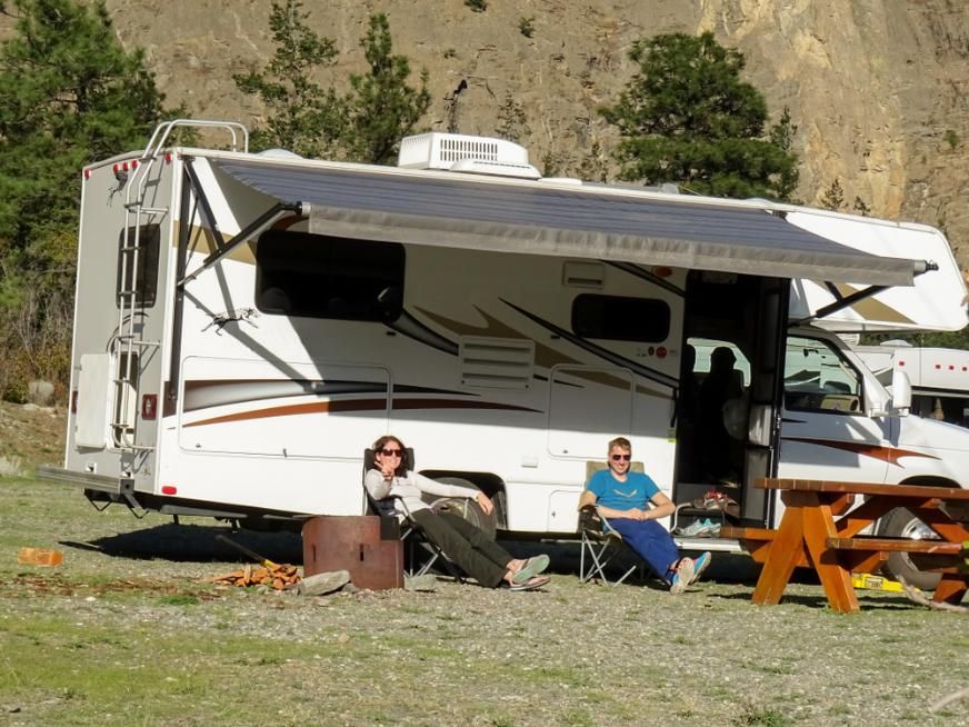 Two People Sit Outside Of A Rv With An Awning — Cairns Caravan Repairs In Edmonton, QLD