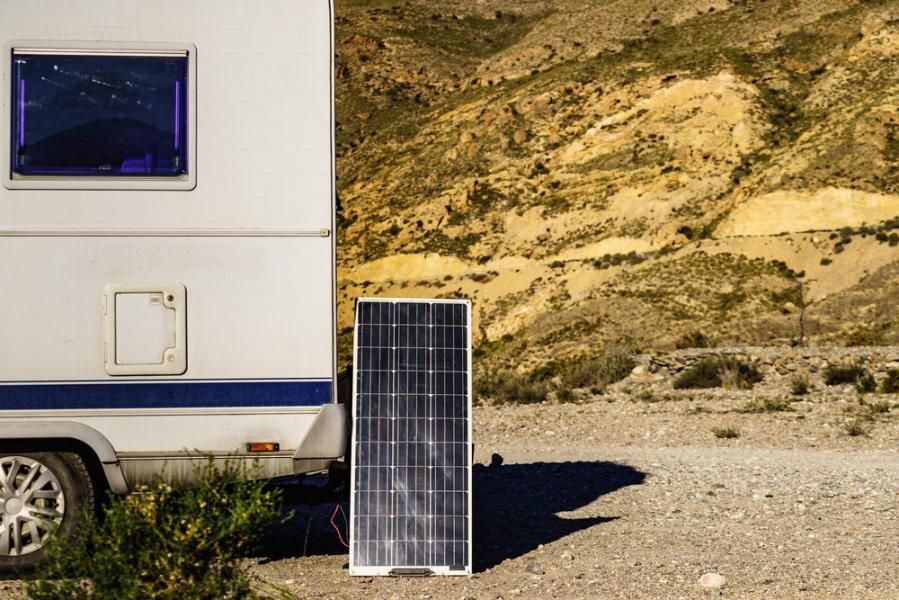 A Solar Panel Is Sitting Next To A Rv In The Desert — Cairns Caravan Repairs In Edmonton, QLD