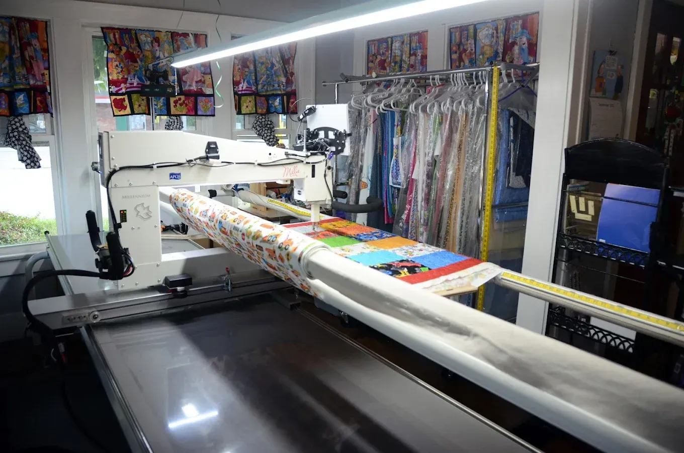 Large-format printer in a print shop, printing a colorful banner on a wide table.
