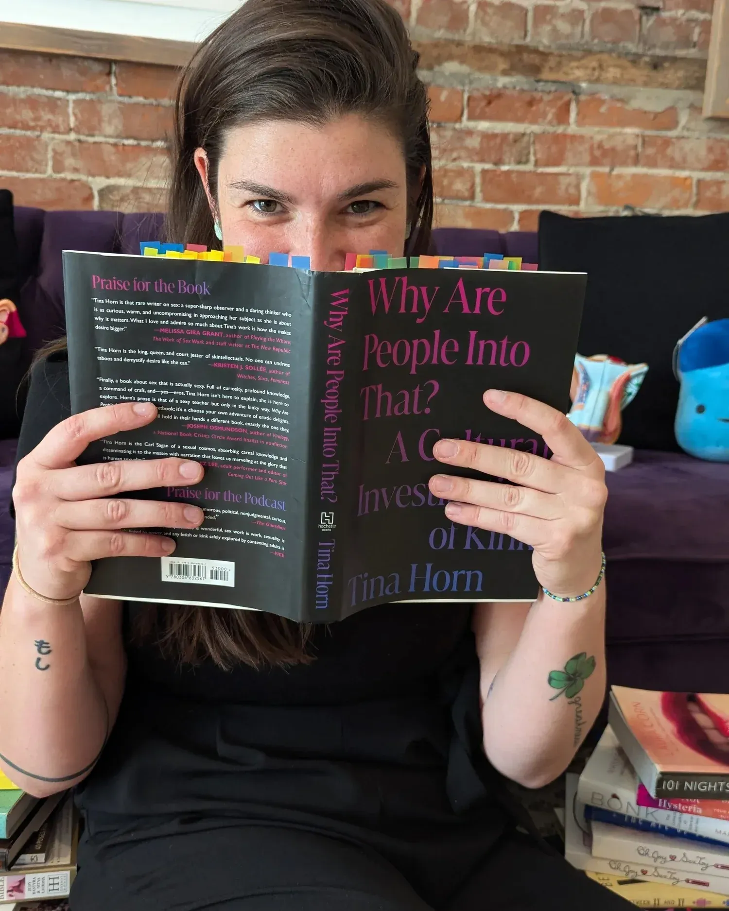 Person on a couch holding a book cover reading “Why Are People Into That?”