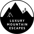Black-and-white circular logo with mountains, cabin, pine trees, and text “Luxury Mountain Escapes”