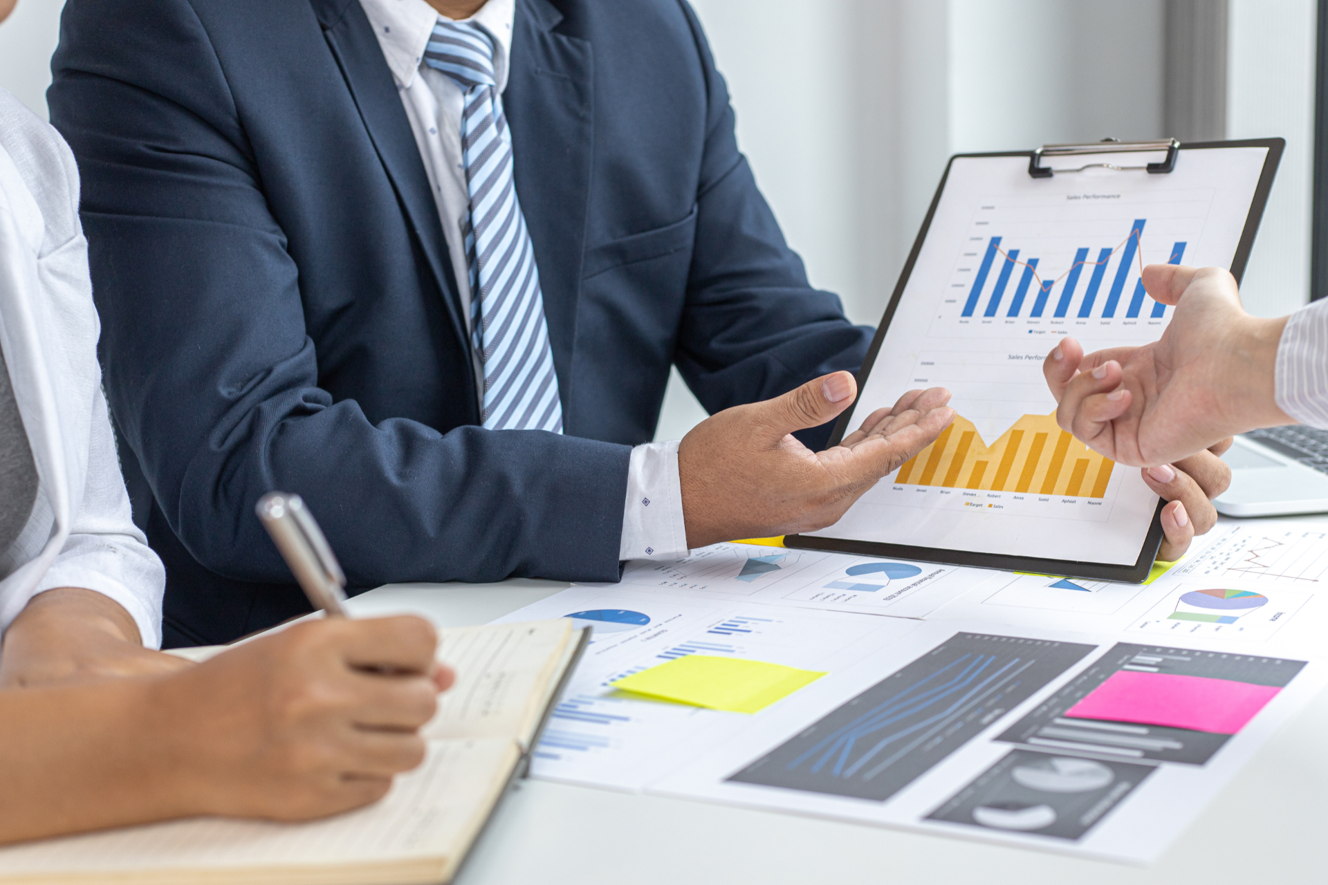 Businesspeople reviewing charts and graphs, discussing data during a meeting.
