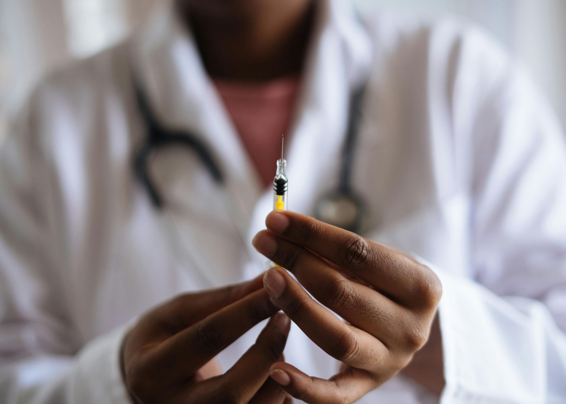 Doctor holding a syringe, ready to administer an injection.