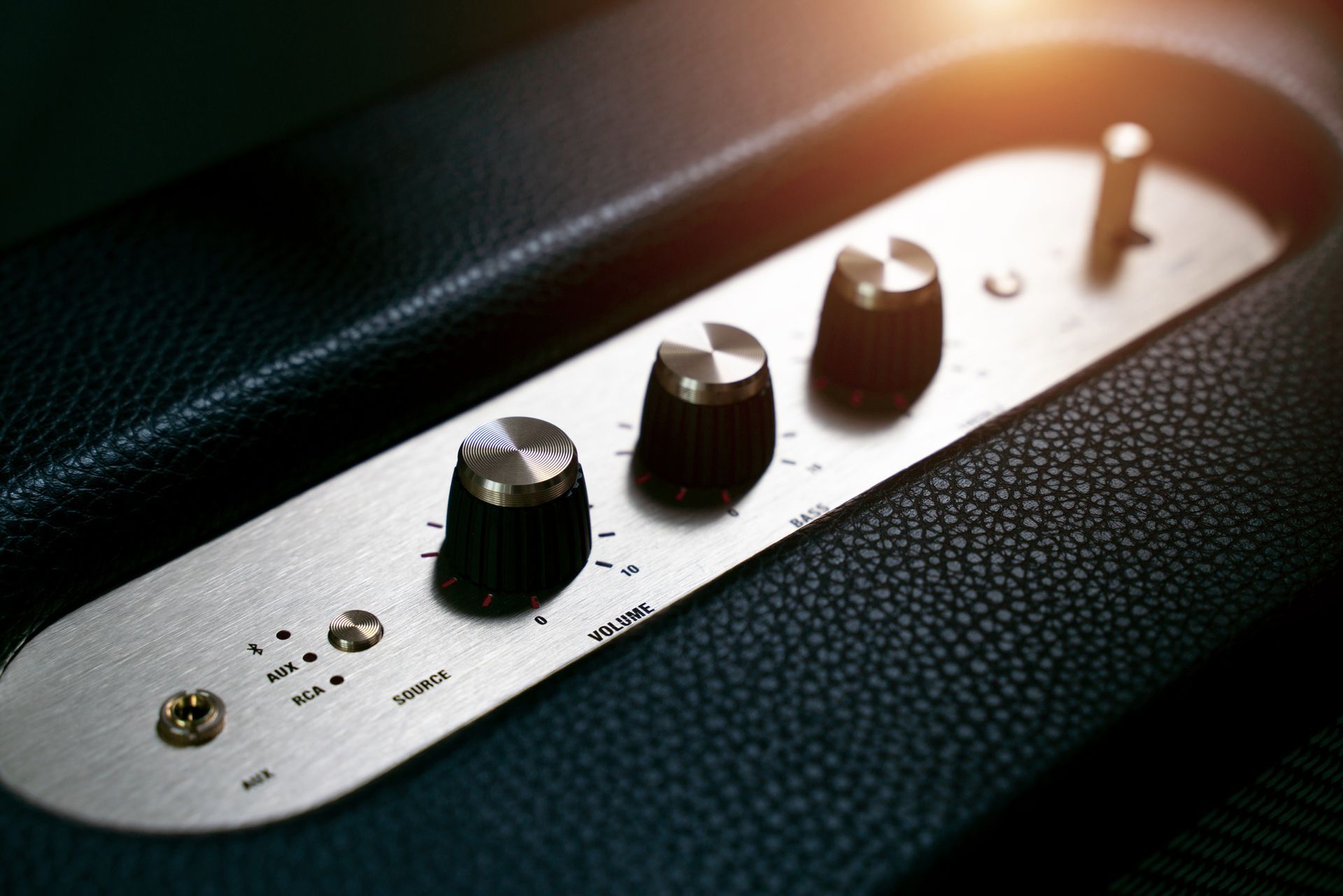 A close up of a speaker with three knobs on it.