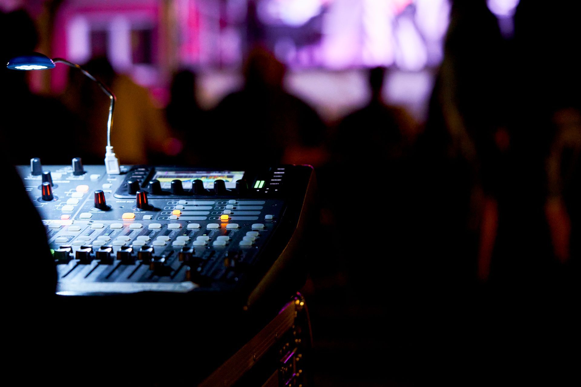 Close-up of a PA hire specialist adjusting digital sound during a live presentation.