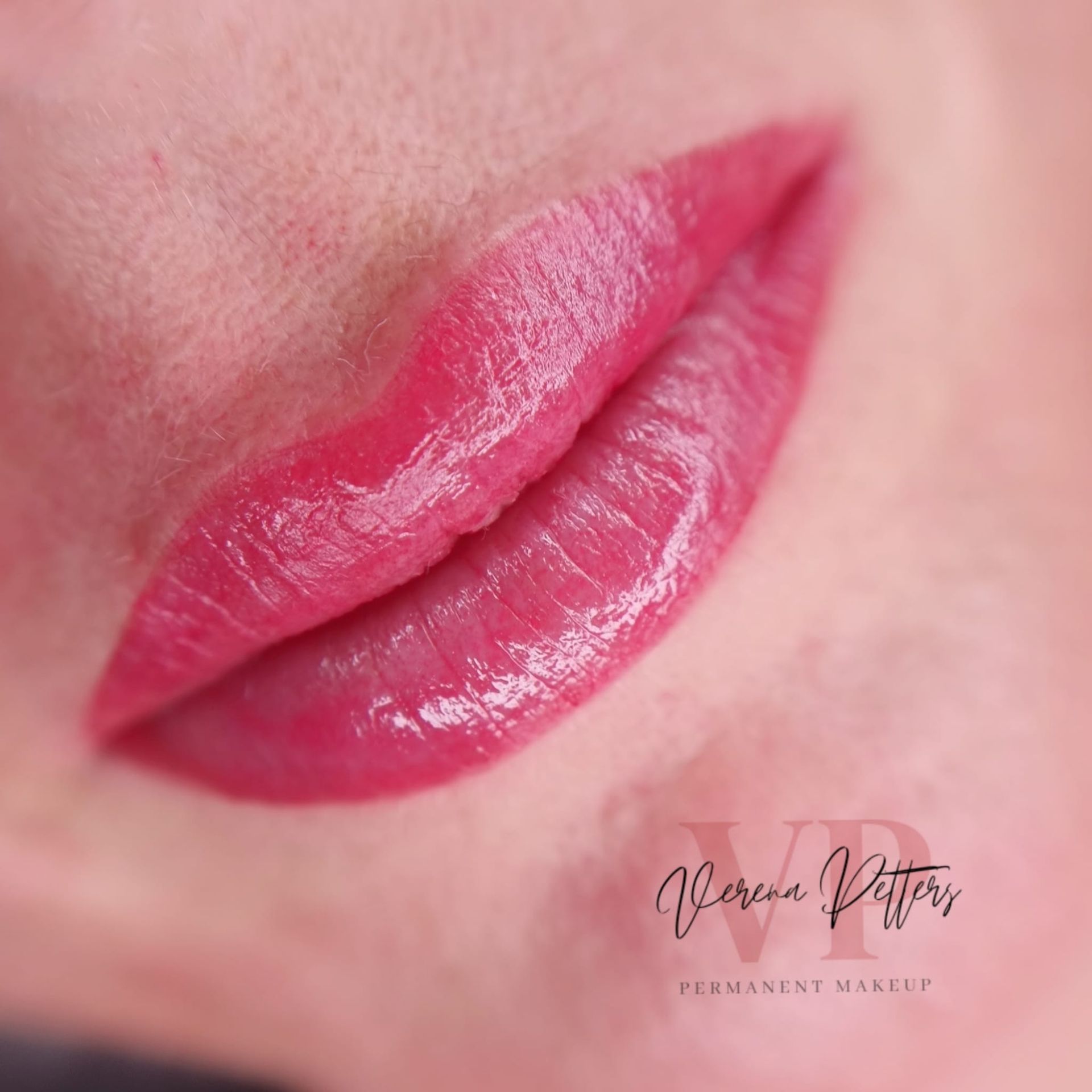 Eine Nahaufnahme der Lippen einer Frau mit rosa Lippenstift.