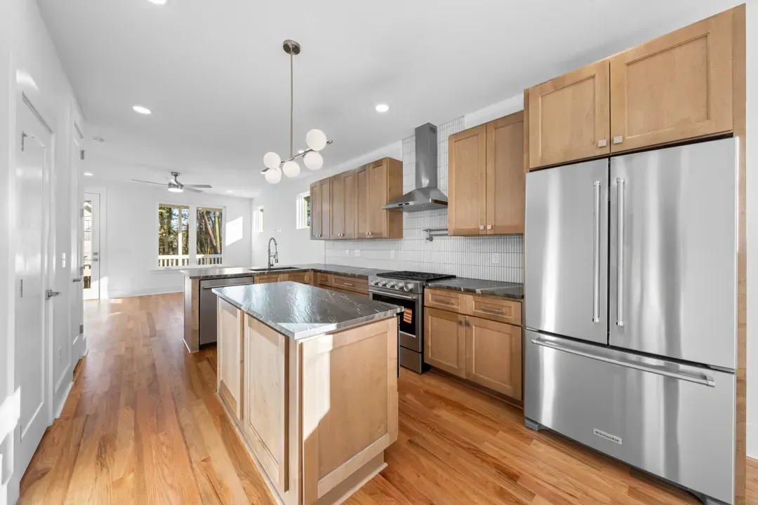 Bright modern kitchen with stainless steel appliances, wood cabinets, and a central island