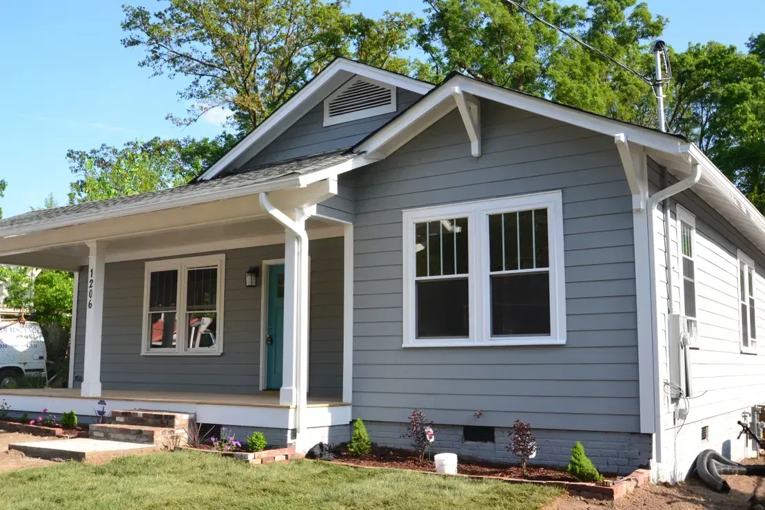Gray house with white trim and front porch on a sunny day