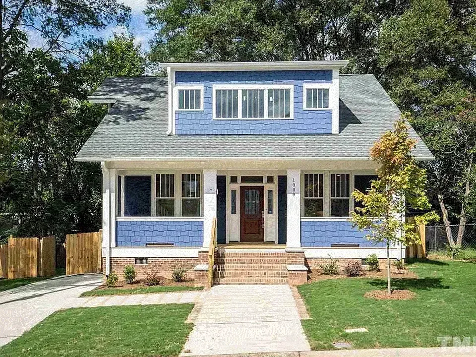 Blue-and-white two-story house with front porch, brick steps, and a green lawn